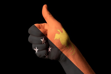Hand with thumb up gesture in colored papua new guinea national flag as symbol of excellence, achievement, good, - for tourism and touristic advertising, positive political, cultural, social management of countryの写真素材