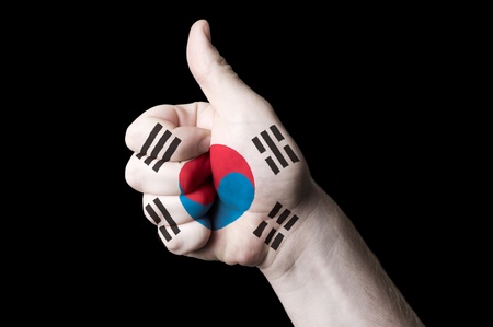 Hand with thumb up gesture in colored south korea national flag as symbol of excellence, achievement, good, - for tourism and touristic advertising, positive political, cultural, social management of countryの写真素材