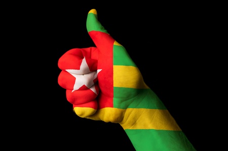 Hand with thumb up gesture in colored togo national flag as symbol of excellence, achievement, good, - for tourism and touristic advertising, positive political, cultural, social management of countryの写真素材