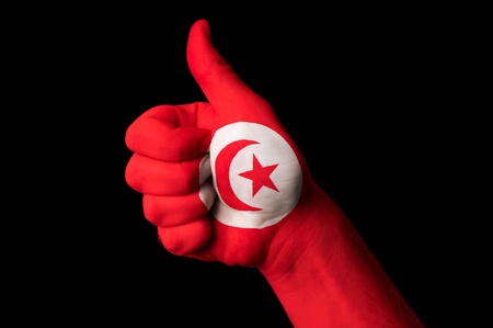 Hand with thumb up gesture in colored tunisia national flag as symbol of excellence, achievement, good, - for tourism and touristic advertising, positive political, cultural, social management of countryの写真素材