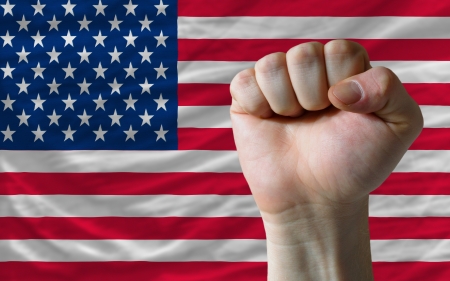 complete american national flag covers whole frame, waved, crunched and very natural looking. In front plan is clenched fist symbolizing determinationの写真素材