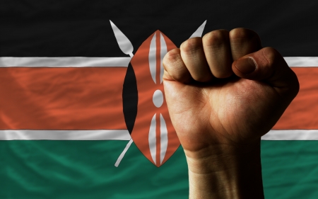 complete national flag of kenya covers whole frame, waved, crunched and very natural looking. In front plan is clenched fist symbolizing determinationの写真素材
