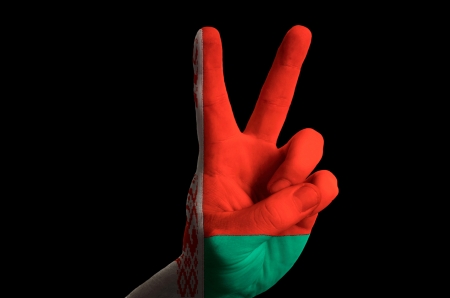 Hand with two finger up gesture in colored belarus national flag as symbol of winning, victorious, excellent, - for tourism and touristic advertising, positive political, cultural, social management of countryの写真素材