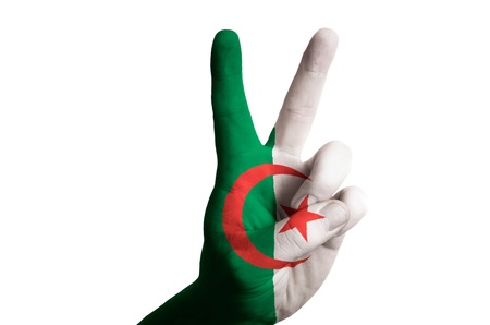 Hand with two finger up gesture in colored algeria national flag as symbol of winning, victorious, excellent, - for tourism and touristic advertising, positive political, cultural, social management of countryの写真素材