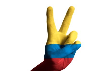 Hand with two finger up gesture in colored colombia national flag as symbol of winning, victorious, excellent, - for tourism and touristic advertising, positive political, cultural, social management of countryの写真素材