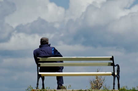 Working man during break sitting on bench and watching into skyの写真素材
