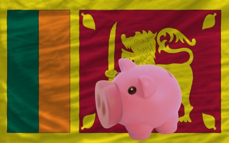 Piggy rich bank in front of national flag of srilanka symbolizing saving and accumulating funds as good financial habitの写真素材