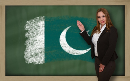 Successful, beautiful and confident woman showing flag of pakistan on blackboard for marketing research, presentation and tourist advertisingの写真素材