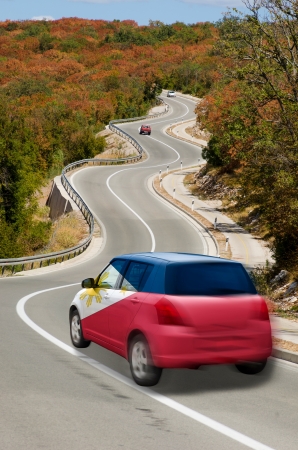 traveling car in national flag of philippines colors and beautiful road landscape for tourism and touristic adertisingの写真素材