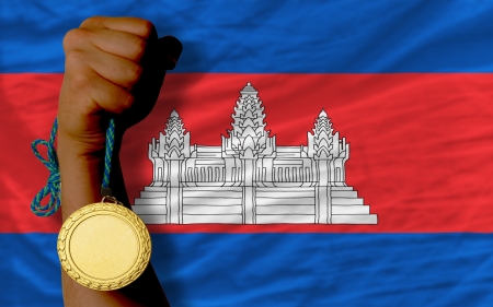 Winner holding gold medal for sport and national flag of cambodiaの写真素材