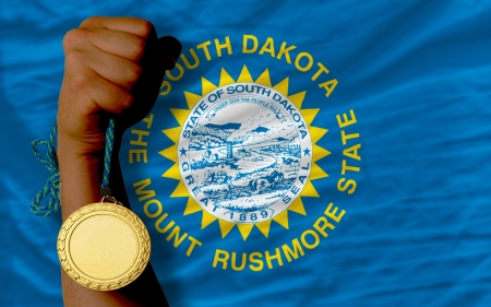 Winner holding gold medal for sport and national flag of south dakotaの写真素材