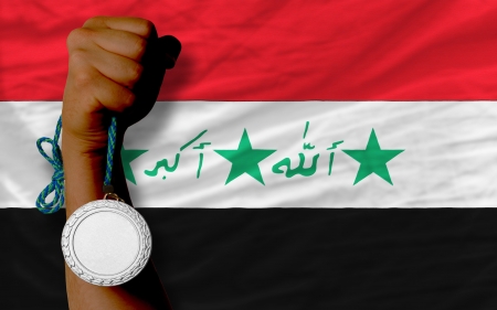 Holding silver medal for sport and national flag of iraqの写真素材