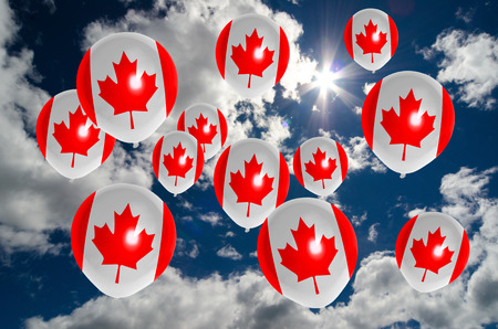 many ballons in colors of canada flag flying on skyの写真素材
