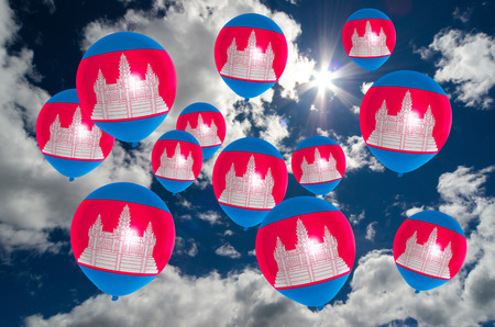 many ballons in colors of cambodia flag flying on skyの写真素材