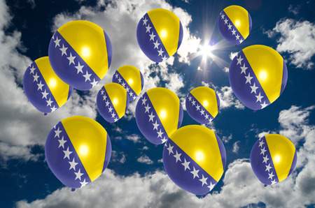 many ballons in colors of bosnia herzegovina flag flying on skyの写真素材