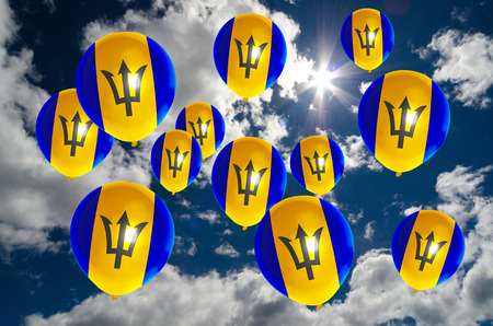 many ballons in colors of barbados flag flying on skyの写真素材