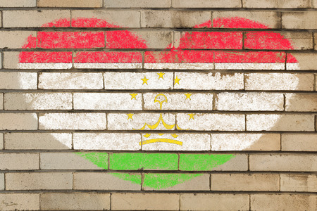 heart shaped flag in colors of tajikistan on brick wallの写真素材