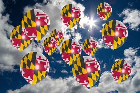 many balloons in colors of maryland flag flying on skyの写真素材