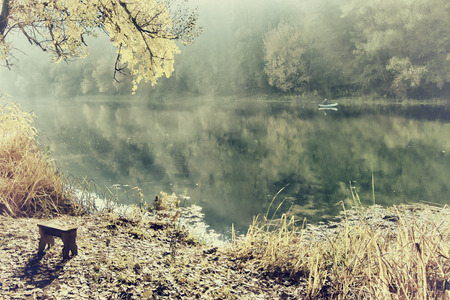 man fishing on a river from the boat at sunrise, vintageの写真素材
