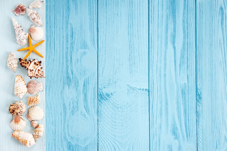 summer background. seashells on blue wooden background.の写真素材