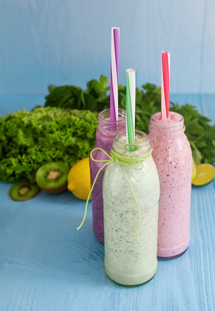 Detox diet, healthy food concept. green smoothie in glass and fresh vegetables and fruits on natural blue wooden backgroundの写真素材