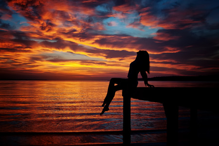 woman silhouette on sunset beachの写真素材