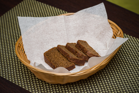 Four slices of black bread on a napkin in a basket