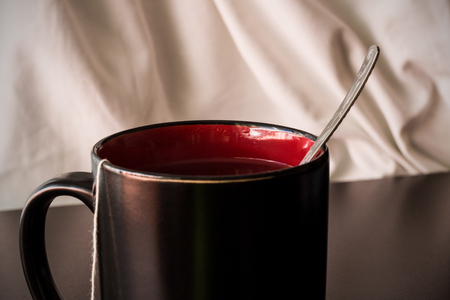 Black cup with tea on a dark wooden table, interior and styleの写真素材