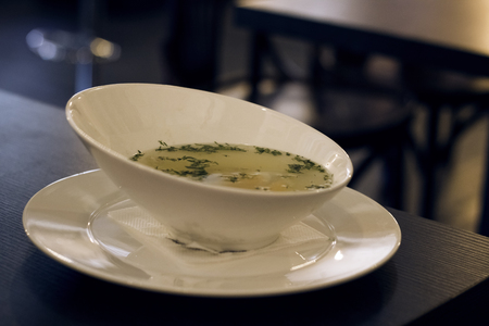 Chicken broth with herbs on a wooden table, healthy foodの写真素材
