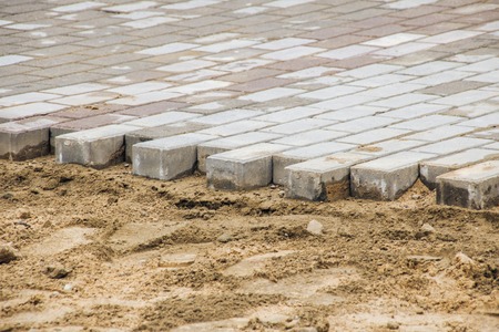 Laying of paving slabs on sand, repair and construction on the streetの写真素材