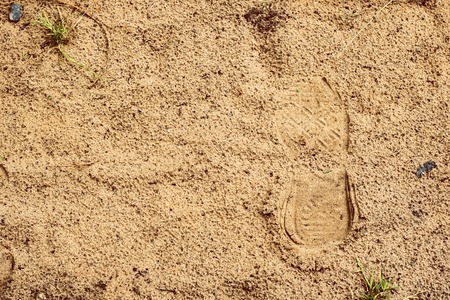 Footprint of a shoe in wet sand, walk along the beachの写真素材