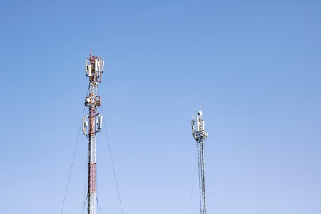 Two antennas on a blue sky background, two cell towersの写真素材
