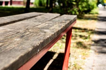 A wooden bench in the alley near to the house, close upの写真素材