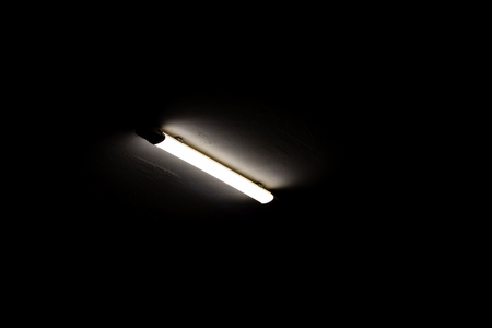 Fluorescent lamp on the ceiling in the dark close upの写真素材
