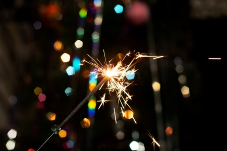 Burning sparkler on the background of New Year's fir, copy space