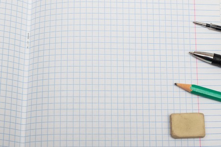 Erased pencil and pens on a sheet of notebook, copy space