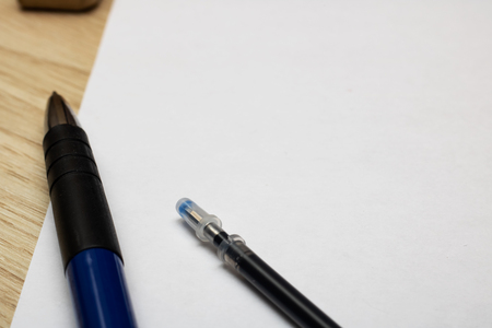 Pens on a sheet of paper on a wooden table close up, copy spaceの写真素材