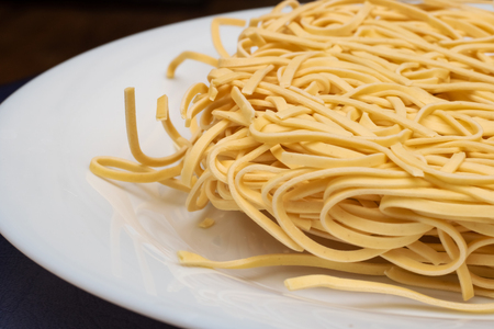 Briquette noodle close up on a white plate, copy space