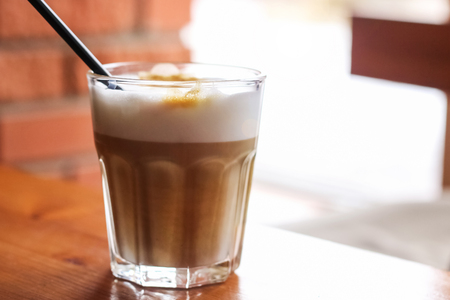 Latte coffee in a glass closeup on wooden tableの写真素材