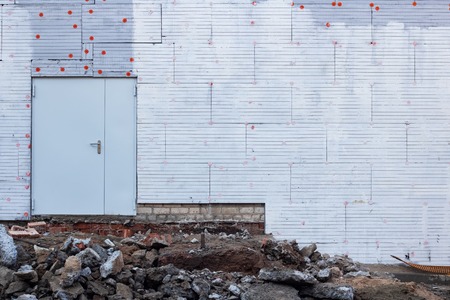Large metal door on a new built wall and construction wasteの写真素材