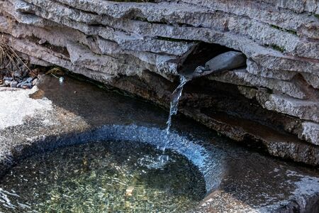 Stream of water in the spring on the stones close up