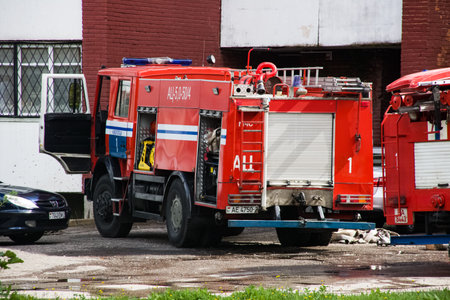 Novopolotsk, Belarus - July 15, 2019: Red fire truck closeup among green treesのeditorial素材