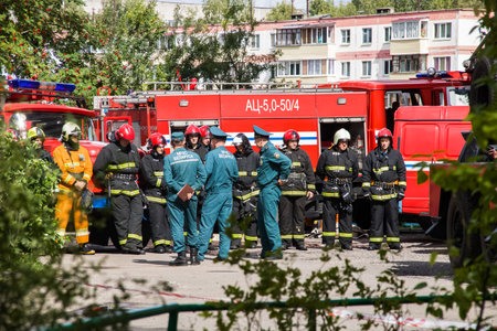 Novopolotsk, Belarus - July 15, 2019: Fire engines and workers in the courtyard of the houseのeditorial素材