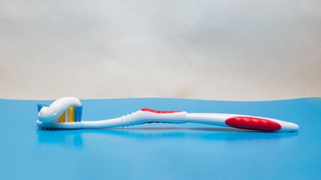 Toothbrush and toothpaste on a blue background close upの写真素材