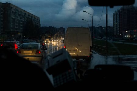 Car front window with raindrops and road with cars at night close upの写真素材