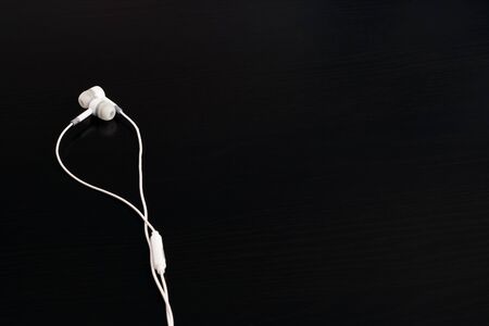 White headphones on a black wooden tableの写真素材