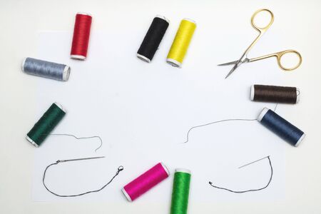 Frame of colorful threads, needles and scissors on white background, backgroundの写真素材