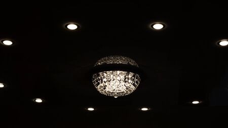 Large retro glass chandelier on the ceiling in the darkの写真素材
