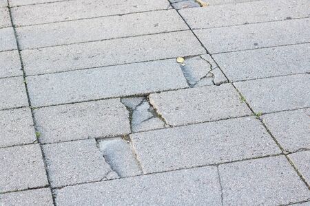 Old broken tile on the sidewalk, background or textureの写真素材