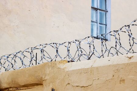 Barbed net on concrete fence of prison close up